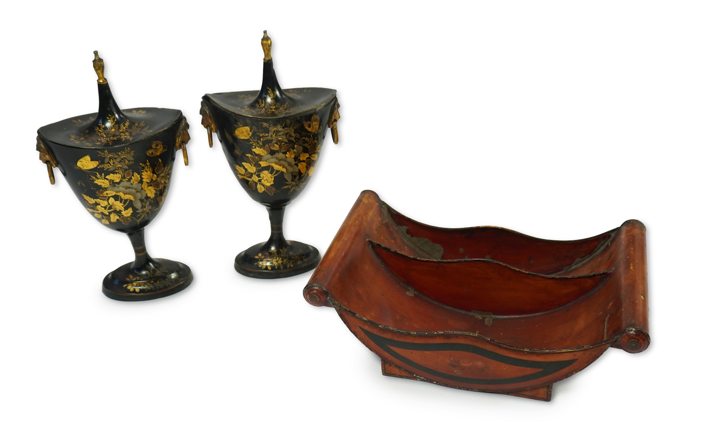 A pair of early 19th century Dutch japanned pewter chest urns and covers, and a tole ware cheese coaster
